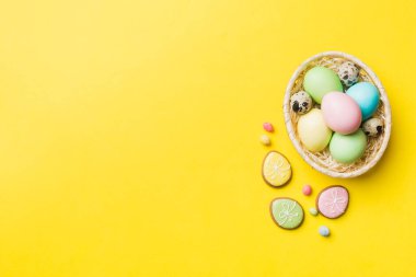 Renkli paskalya kurabiyeleri sepette renkli arka planda çok renkli Paskalya yumurtaları. Pastel renginde Paskalya yumurtası. Kopyalama alanı olan tatil kavramı.