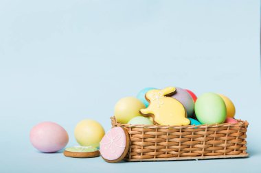 Renkli paskalya kurabiyeleri sepette renkli arka planda çok renkli Paskalya yumurtaları. Pastel renginde Paskalya yumurtası. Kopyalama alanı olan tatil kavramı.