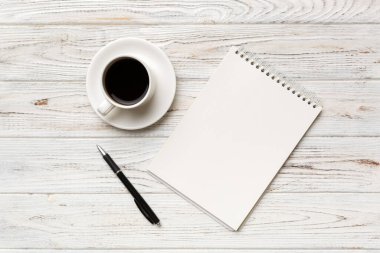 Defterli modern ofis masası ve bir fincan kahveli diğer malzemeler. Tasarım için boş defter sayfası. Üst manzara, düz uzanma.