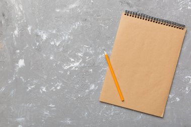 Renkli bir arka planda okul kahverengi defteri, bir masadaki spiral el işi not defteri..