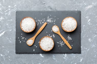 Ahşap bir arka planda ahşap bir kase tuz kristali. Kırsal kaselerdeki tuz, fotokopi alanı olan üst görünüm.