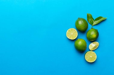 Yeşil yapraklı kireç meyveleri ve beyaz arka planda yarım dilim kesilmiş. Üst Manzara. Kopyalama alanı olan düz.