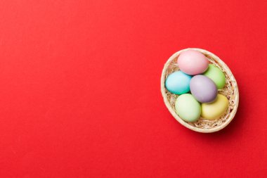 Renkli arka planda dokuma sepetinde çok renkli Paskalya yumurtaları. Pastel renginde Paskalya yumurtası. Kopyalama alanı olan tatil kavramı.