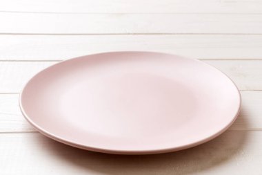 Ahşap arka planda boş pembe plaka manzarası. Tasarımın için boş boşluk.