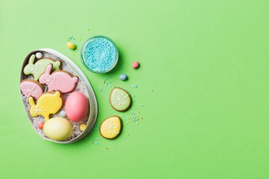 Renkli paskalya kurabiyeleri sepette renkli arka planda çok renkli Paskalya yumurtaları. Pastel renginde Paskalya yumurtası. Kopyalama alanı olan tatil kavramı.