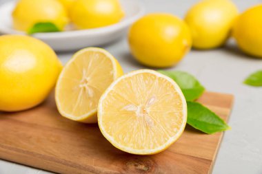 Kesme tahtasındaki taze ve olgun limonlar için fotokopi alanı olan üst manzara. Sağlıklı yemek geçmişi. Limon ve limon dilimlerinin zarif arkaplanı daha sıkan renkli arkaplan.