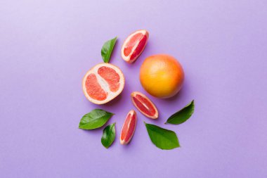 Renkli arka planda sulu greyfurt dilimli taze meyve greyfurdu. Üst Manzara. Uzayı kopyala yaratıcı yaz konsepti. Minimum düzlükte turunçgillerin yarısı kopyalama alanı ile yatar.