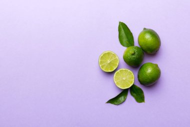Yeşil yapraklı kireç meyveleri ve beyaz arka planda yarım dilim kesilmiş. Üst Manzara. Kopyalama alanı olan düz.