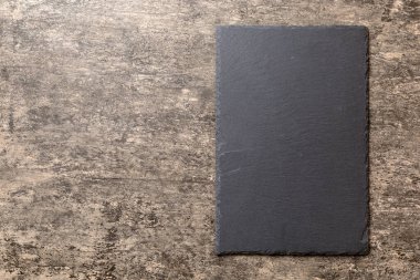 Beton zemin üzerinde boş siyah levha üst görünümü. Tasarımın için boş boşluk.