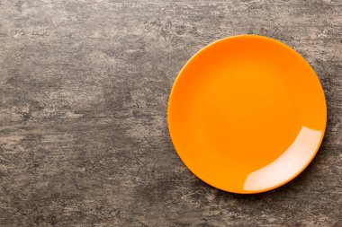 Çimento arka planındaki boş turuncu plakanın üst görüntüsü. Tasarımın için boş boşluk.