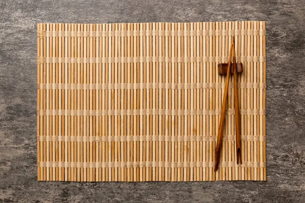 Dois Pauzinhos Esteira Bambu Fundo Cimento Vista Superior Espaço Cópia — Fotografia de Stock
