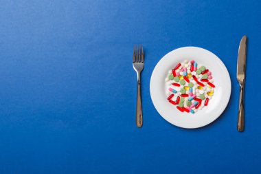 Yuvarlak tabakta yemek olarak birçok farklı kilo kaybı hapı ve takviye maddesi var. Haplar sağlıklı bir yemek olarak sunuldu. Uyuşturucu, eczane, ilaç veya sağlık hizmetleri kavramı.