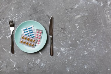 Yuvarlak tabakta yemek olarak birçok farklı kilo kaybı hapı ve takviye maddesi var. Haplar sağlıklı bir yemek olarak sunuldu. Uyuşturucu, eczane, ilaç veya sağlık hizmetleri kavramı.