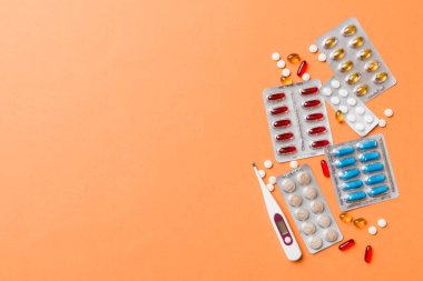 Masa arkasında koruyucu yüz maskeleri, cerrahi maskeler, ilaç hapları ve termometre. Coronavirus hastalığı. Corona virüsü konsepti. Metin için boşluk.