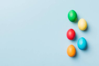 Bayram hazırlığı. Renkli arka planda Paskalya yumurtaları. Pastel renginde Paskalya yumurtası. Kopyalama alanı olan tatil kavramı.