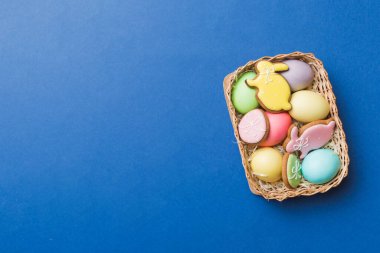 Renkli paskalya kurabiyeleri sepette renkli arka planda çok renkli Paskalya yumurtaları. Pastel renginde Paskalya yumurtası. Kopyalama alanı olan tatil kavramı.