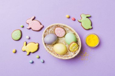 Renkli paskalya kurabiyeleri sepette renkli arka planda çok renkli Paskalya yumurtaları. Pastel renginde Paskalya yumurtası. Kopyalama alanı olan tatil kavramı.