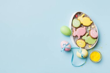 Renkli paskalya kurabiyeleri sepette renkli arka planda çok renkli Paskalya yumurtaları. Pastel renginde Paskalya yumurtası. Kopyalama alanı olan tatil kavramı.