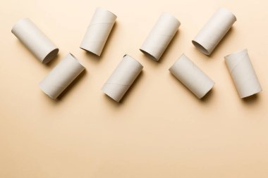 Boş tuvalet kağıdı ruloları ve renk arkaplanı üzerine metin için alanı olan düz bir kompozisyon. Kraft kağıdı veya kartondan yapılmış metal kapaklı geri dönüşümlü kağıt tüp.