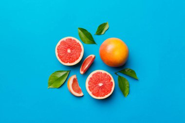 Renkli arka planda sulu greyfurt dilimli taze meyve greyfurdu. Üst Manzara. Uzayı kopyala yaratıcı yaz konsepti. Minimum düzlükte turunçgillerin yarısı kopyalama alanı ile yatar.