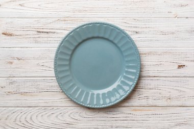 Ahşap zemindeki boş gri tabağın üst görüntüsü. Tasarımın için boş boşluk.