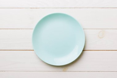 Ahşap zemindeki boş mavi tabağın üst görüntüsü. Tasarımın için boş boşluk.