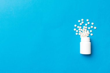Renkli arka planda plastik şişede çok renkli haplar ve kapsüller, kopyalama alanı. Çeşitli ilaç tabletleri ve haplar, vitamin ve besin takviyeleri kavramı.