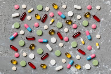 Renkli arka plan ve üst görünüm üzerine yazılmış metinler için birçok farklı hap ve alan. Renkli arka planda farklı haplar, düz yatış.