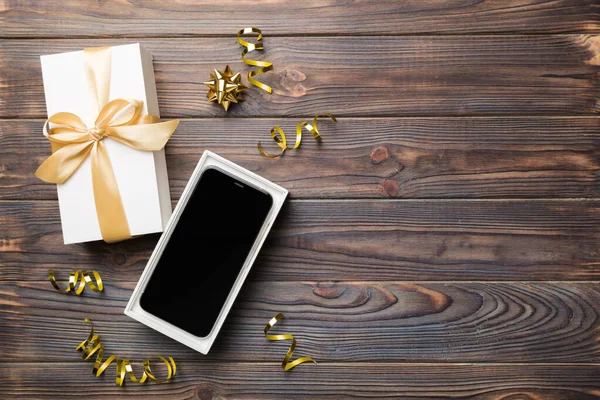 Ανοιγμένο Κουτί Δώρου Χρυσή Κορδέλα Και Smartphone Στο Φόντο Χρώμα — Φωτογραφία Αρχείου