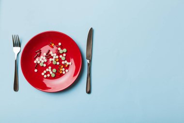 Yuvarlak tabakta yemek olarak birçok farklı kilo kaybı hapı ve takviye maddesi var. Haplar sağlıklı bir yemek olarak sunuldu. Uyuşturucu, eczane, ilaç veya sağlık hizmetleri kavramı.
