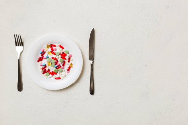 Yuvarlak tabakta yemek olarak birçok farklı kilo kaybı hapı ve takviye maddesi var. Haplar sağlıklı bir yemek olarak sunuldu. Uyuşturucu, eczane, ilaç veya sağlık hizmetleri kavramı.