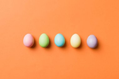 Bayram hazırlığı. Renkli arka planda Paskalya yumurtaları. Pastel renginde Paskalya yumurtası. Kopyalama alanı olan tatil kavramı.