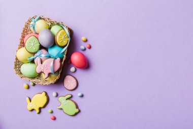 Renkli paskalya kurabiyeleri sepette renkli arka planda çok renkli Paskalya yumurtaları. Pastel renginde Paskalya yumurtası. Kopyalama alanı olan tatil kavramı.