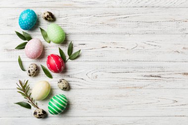 Beyaz arka planda yay yaprağı olan renkli Paskalya yumurtaları. Renkli Yumurta Tatil Kenarı.