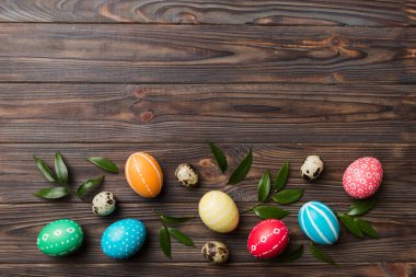 Beyaz arka planda yay yaprağı olan renkli Paskalya yumurtaları. Renkli Yumurta Tatil Kenarı.