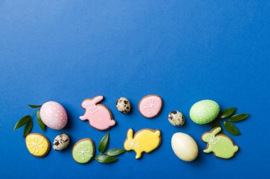 bayram hazırlığı renkli arka planda kurabiyeli çok renkli Paskalya yumurtaları. Pastel renginde Paskalya yumurtası. Kopyalama alanı olan tatil kavramı.