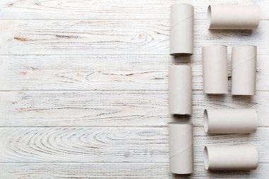 Boş tuvalet kağıdı ruloları ve renk arkaplanı üzerine metin için alanı olan düz bir kompozisyon. Kraft kağıdı veya kartondan yapılmış metal kapaklı geri dönüşümlü kağıt tüp.