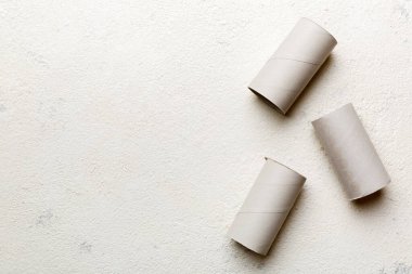 Boş tuvalet kağıdı ruloları ve renk arkaplanı üzerine metin için alanı olan düz bir kompozisyon. Kraft kağıdı veya kartondan yapılmış metal kapaklı geri dönüşümlü kağıt tüp.