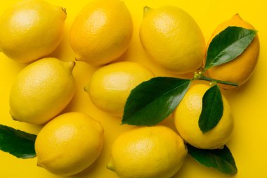 Renkli arka plan olarak pek çok taze limon, üst manzara. Limon ve limon dilimlerinin zarif arka planı Üst görünüm düz yatıyordu.