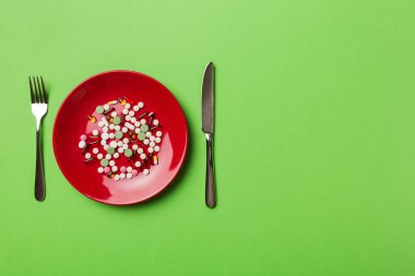 Yuvarlak tabakta yemek olarak birçok farklı kilo kaybı hapı ve takviye maddesi var. Haplar sağlıklı bir yemek olarak sunuldu. Uyuşturucu, eczane, ilaç veya sağlık hizmetleri kavramı.