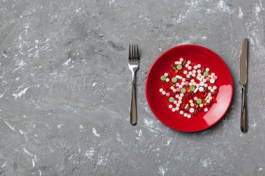 Yuvarlak tabakta yemek olarak birçok farklı kilo kaybı hapı ve takviye maddesi var. Haplar sağlıklı bir yemek olarak sunuldu. Uyuşturucu, eczane, ilaç veya sağlık hizmetleri kavramı.