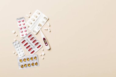 Masa arkasında koruyucu yüz maskeleri, cerrahi maskeler, ilaç hapları ve termometre. Coronavirus hastalığı. Corona virüsü konsepti. Metin için boşluk.