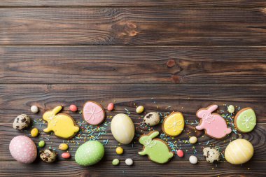 bayram hazırlığı renkli arka planda kurabiyeli çok renkli Paskalya yumurtaları. Pastel renginde Paskalya yumurtası. Kopyalama alanı olan tatil kavramı.