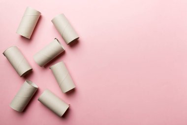 Boş tuvalet kağıdı ruloları ve renk arkaplanı üzerine metin için alanı olan düz bir kompozisyon. Kraft kağıdı veya kartondan yapılmış metal kapaklı geri dönüşümlü kağıt tüp.