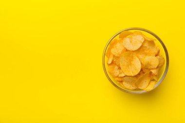 Renkli arka planda izole edilmiş patates cipsi. Lezzetli çıtır patates cipsi kasede. Mesaj için yer var. Üst görünüm.