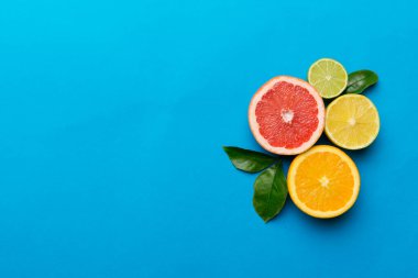 Meyve arkaplanı. Renkli masada renkli taze meyveler. Portakal, limon, greyfurt. Sağlıklı yazı kavramı için. Düz konum, üst görünüm, kopyalama alanı.