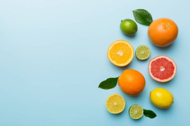 Meyve arkaplanı. Renkli masada renkli taze meyveler. Portakal, limon, greyfurt. Sağlıklı yazı kavramı için. Düz konum, üst görünüm, kopyalama alanı.