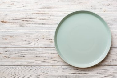 Ahşap zemindeki boş mavi tabağın üst görüntüsü. Tasarımın için boş boşluk.