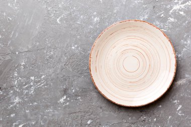 Ahşap zemindeki boş renkli tabağın üst görünümü. Tasarımın için boş boşluk.