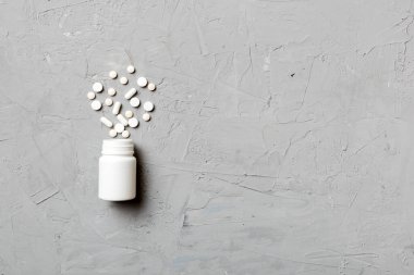 Renkli arka planda plastik şişede çok renkli haplar ve kapsüller, kopyalama alanı. Çeşitli ilaç tabletleri ve haplar, vitamin ve besin takviyeleri kavramı.